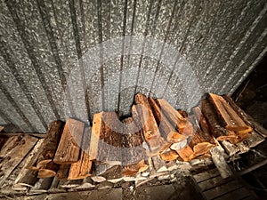 Firewood Stack Against Corrugated Metal Wall