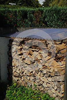 Firewood stacked in piles outside house