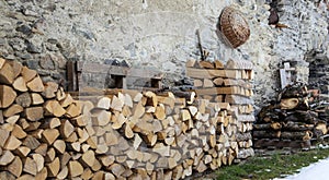 firewood stored along a stone wall of a traditional chalet