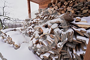 Firewood supplies for the winter lie under the snow