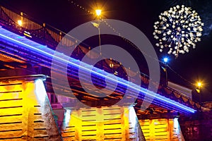 Firework over bridge night city reflected in water Uzhorod