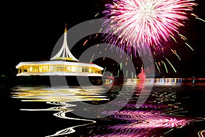 Fireworks on the black sky background with reflection on water a