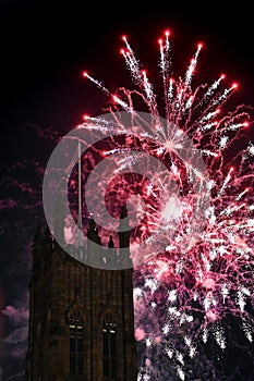 Fireworks display with a tower in the foreground