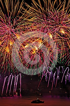 Fireworks display with yellow and pink sky over Geneva