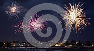 Fireworks explode above a night landscape