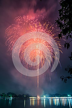 Fireworks on the lagoon against blue sky in public park, Suanluang Rama 9