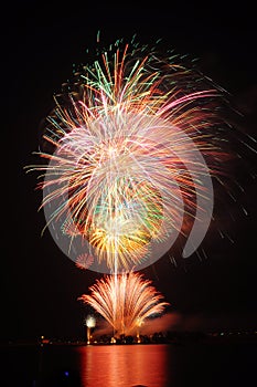 Fireworks light up the sky over river. Copy space.