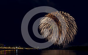 Fireworks over the river in a modern city. Celebratory firework entertainments