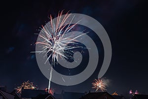 Fireworks over the roofs of houses