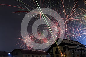 Fireworks over the snowy roofs on New Year`s Eve