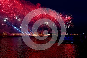 Fireworks over the water Holiday light. Night cityscape scene. Neva river, Saint-Petersburg, Russia. Holiday Scarlet Sails