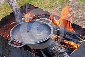 Firing a cast iron skillet over an open fire. Cast iron skillet over an red fire heats up for further cooking