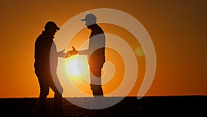 Firm handshake between two men at sunset