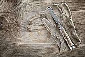 Firmer chisel working gloves on wooden board