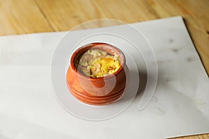 Firni, phirni anf kheer with nuts served in pot isolated on mat top view of indian, bangali and pakistani dessert mithai