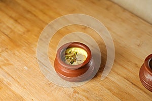 Firni, phirni anf kheer with nuts served in pot isolated on mat top view of indian, bangali and pakistani dessert mithai