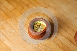 Firni, phirni anf kheer with nuts served in pot isolated on mat top view of indian, bangali and pakistani dessert mithai