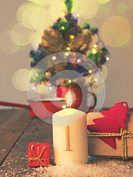 First Advent candle burning with gift boxes, vintage tone stylized