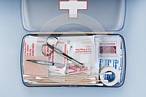 First aid kit packed with medical supplies on grey background