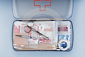 First aid kit packed with medical supplies on grey background
