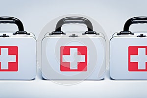 First aid kits in a row on light grey background photo