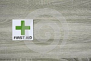 First aid sign on the wooden wall with space for adding text on the right side
