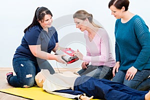 First aid trainees learning to use defibrillator for reanimation photo