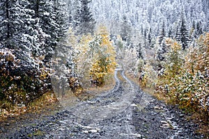 First autumn snow and rural road in mountains