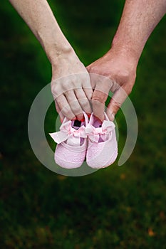 First baby girl shoes in a parent hands