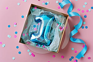 First birthday gift box with number 1 balloon inside, confetti and ribbons on a pastel background