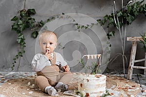 First birthday of a little boy, eating cake, one year old toddler. Kid with a cake in the studio. Children's birthday