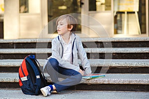 First class. Back to school concept. Pupil with books and backpack outside school. Education