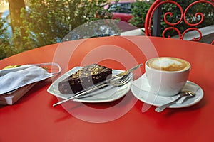 The first cup of coffee and cake in the cafe after the weakening of quarantine COVID-19