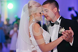 Portrait of first dance of stylish wedding couple. Handsome groom and elegant bride in the restaurant