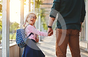 First day at school. father leads little child school girl in f