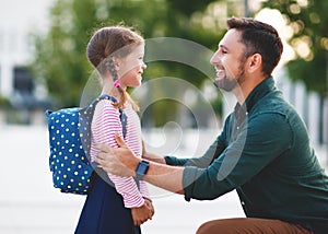 First day at school. father leads little child school girl in f