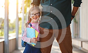 First day at school. father leads little child school girl in f