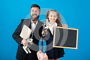 First day at school. Father and little child school girl in first grade. Amazed teacher with excited happy pupil school