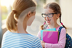 First day at school. mother leads little child school girl in f