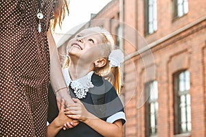 First day at school. Mother leads a little child school girl in first grade.