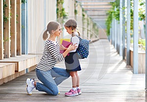 First day at school. mother leads little child school girl in f