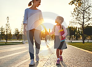 First day at school. mother leads little child school girl in f