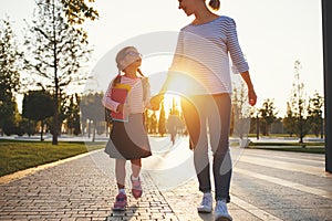 First day at school. mother leads little child school girl in f