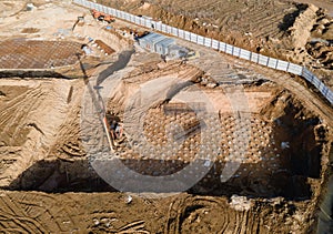 First floor slab rebar installation. Pile driver at construction site. Pile driven into ground by vibrating hydraulic hammer.