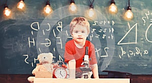 First former interested in studying, learning, education. Child on cheerful face near clock and teddy bear. Primary