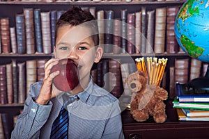 First-grader boy eating apple