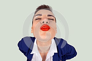 First kiss, unwanted kiss concept. Closeup portrait of nerdy young funny distorted woman face with big red lips eyes closed trying