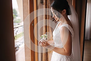 First look of groom and bride at brides`s home. Tender bride Stand by the window and wait for groom