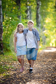 First love. Little boy and girl holding hands and smiling while walking outdoors in park