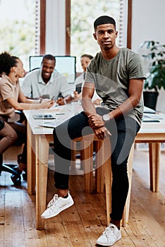 First we meet, then we make things happen. Portrait of a confident young businessman with his team having a meeting in